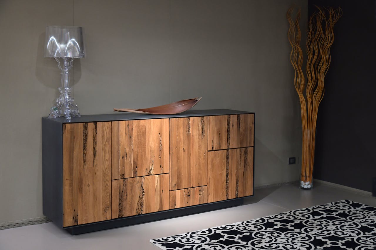 Stylish wooden cabinet with glass lamp in a contemporary interior setting.
